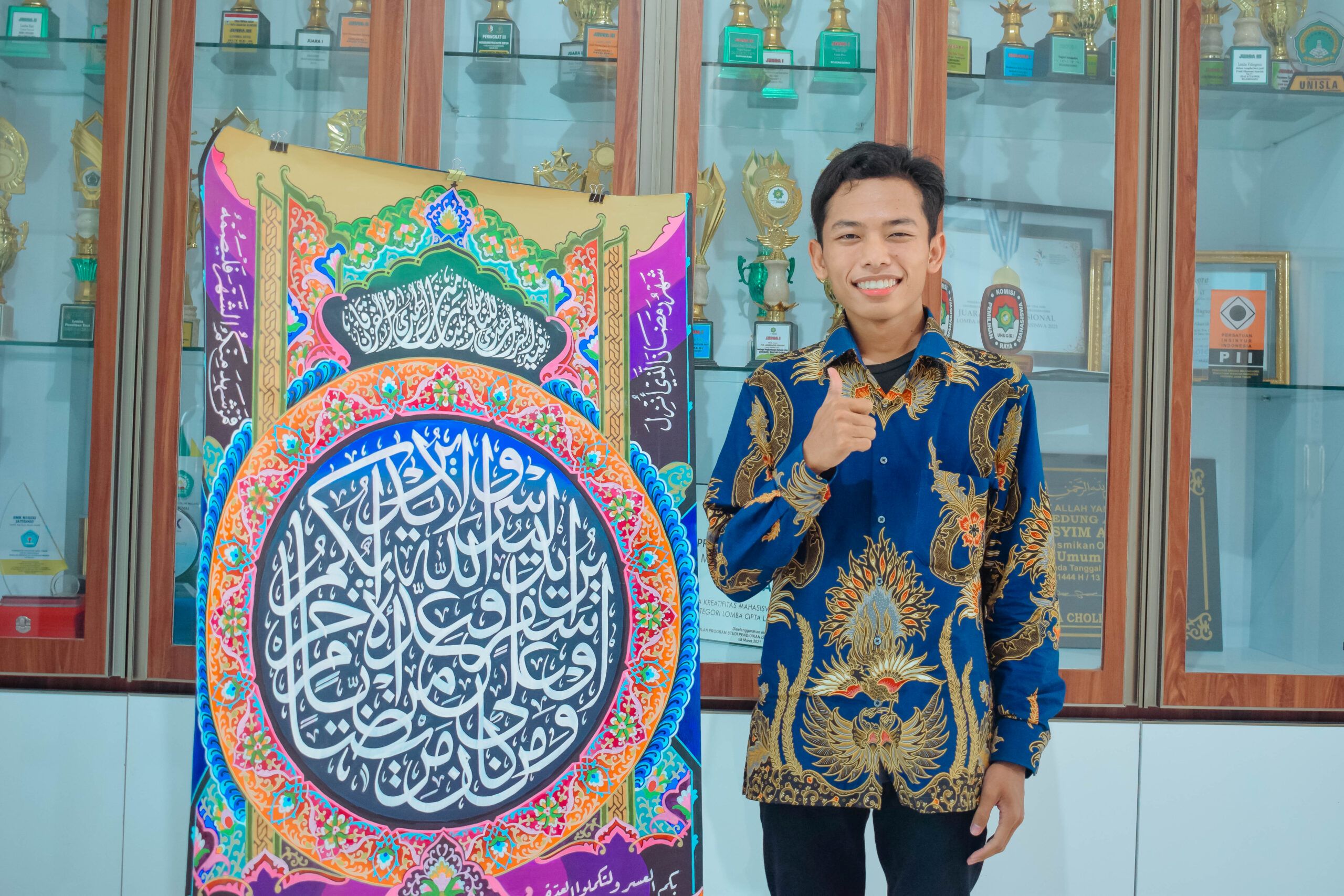 KARYA KALIGRAFI-Nur Maulana Hidayat mahasiswa Prodi PAI Unugiri Juara II Lomba MTQ Cabang Musabaqah Khaththil Qur’an kategori Dekorasi Tingkat Nasional di UNY baru-baru ini. (foto.rohim)